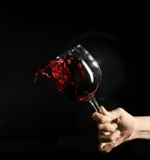 crop-hand-splashing-wine-from-glass